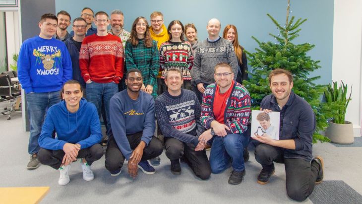 The Brightec team wearing Christmas Jumpers next to the tree