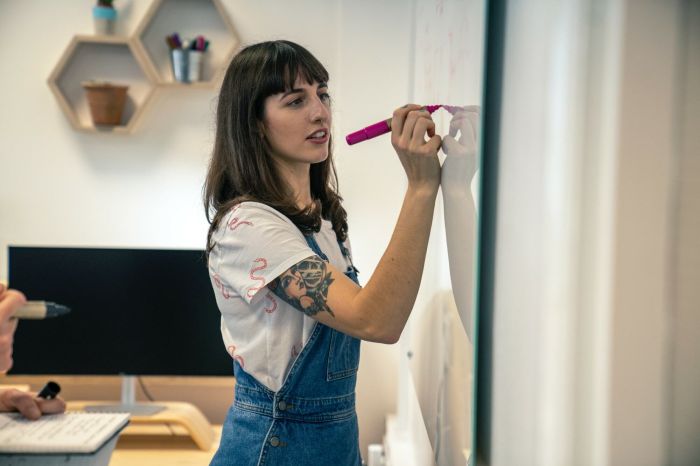 Elle Daintree writing on a glass white board