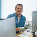 Andy sitting in the Brightec office smiling as he thinks about leading a remote team