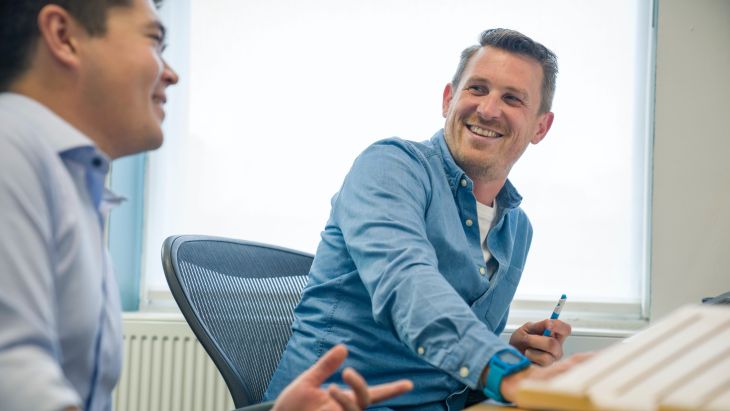 Andy sitting at a desk with one of the Brightec team