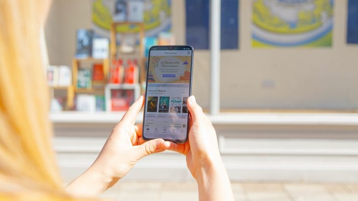 A lady using the waterstones app on her phone