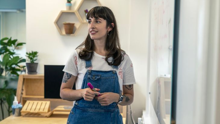 Elle using a whiteboard to consider feedback