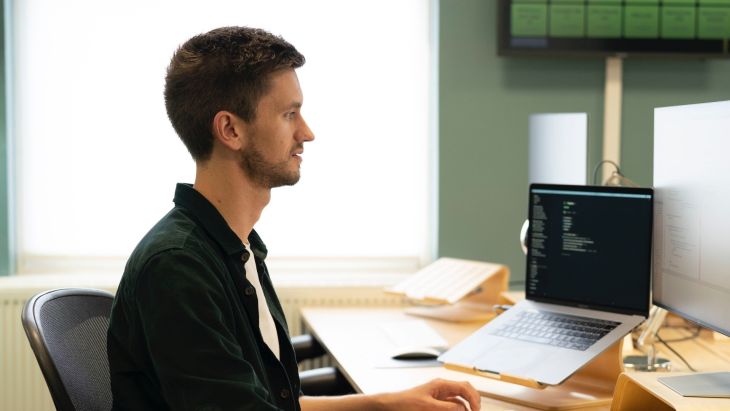 Jonny working at his desk with his laptop